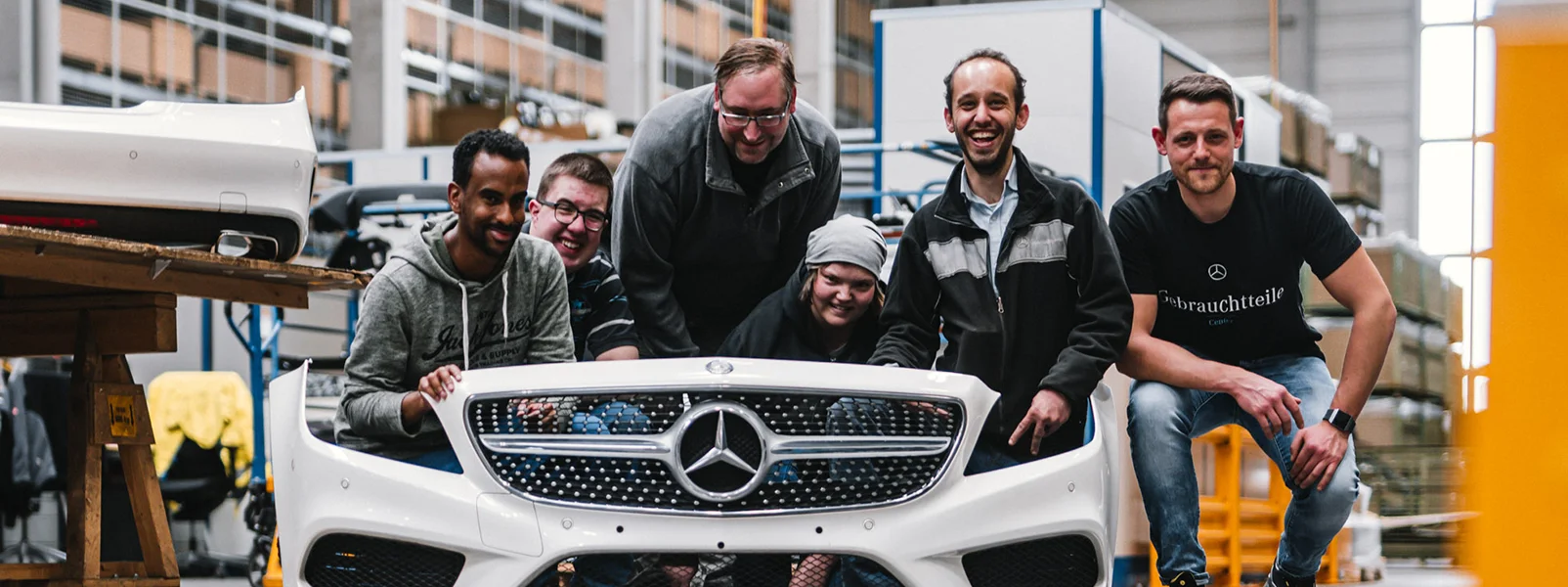 Employees with and without disabilities working side by side on a vehicle front at our Neuhausen auf den Fildern site — this is inclusion and social responsibility in action.